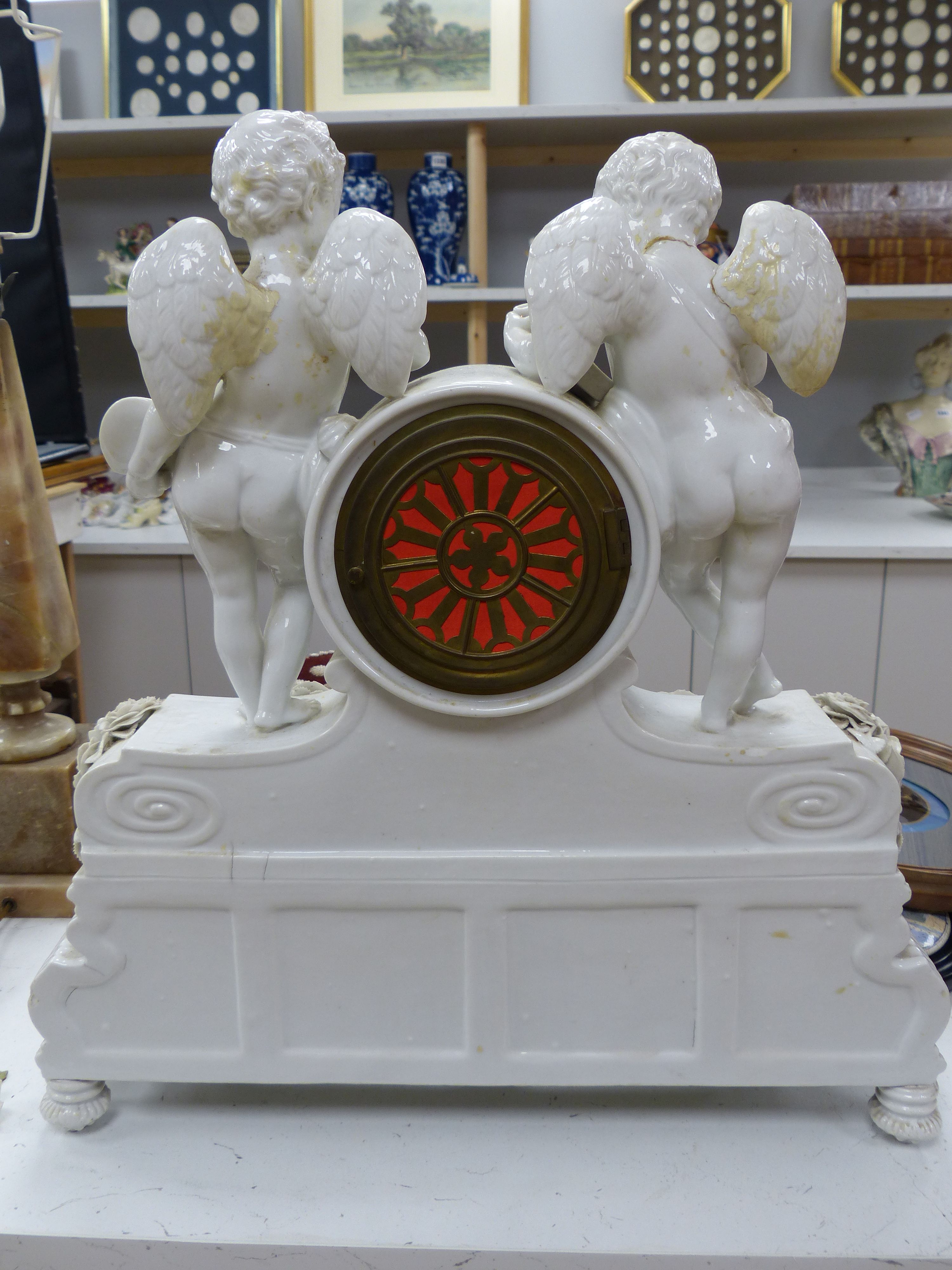 A large French porcelain white glazed cherub mantel clock, height 49cm